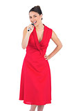 Happy elegant brunette in red dress singing