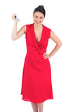 Smiling elegant brunette in red dress holding knife
