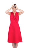 Anxious elegant brunette in red dress posing