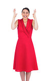 Surprised elegant brunette in red dress posing