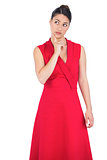Thoughtful elegant brunette in red dress posing