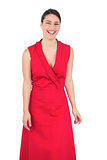 Cheerful elegant model in red dress posing
