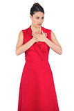 Offended elegant model in red dress posing