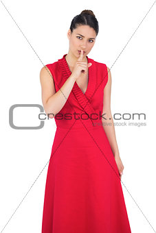 Glamorous model in red dress keeping secret