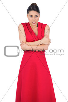 Glamorous model in red dress being cold
