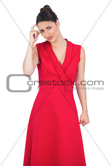 Worried glamorous model in red dress posing