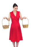 Content glamorous model in red dress holding baskets