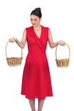 Peaceful glamorous model in red dress holding baskets