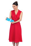 Cheerful glamorous model in red dress holding present