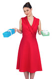 Content glamorous model in red dress offering presents