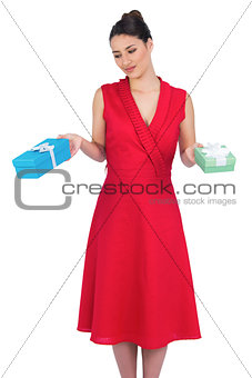 Content glamorous model in red dress offering presents