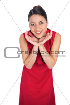 Surprised mysterious brunette in red dress posing