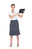 Serious businesswoman showing something on her tablet pc