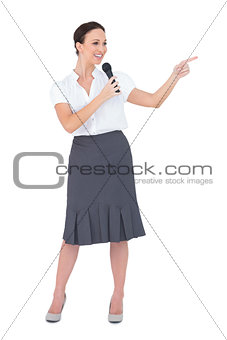 Attractive presenter holding microphone pointing