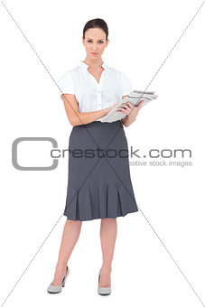 Pretty businesswoman holding newspaper