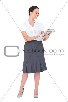 Smiling classy businesswoman holding newspaper