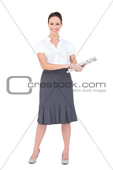 Cheerful classy businesswoman holding newspaper