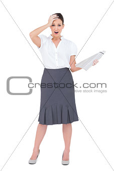 Shocked classy businesswoman holding newspaper