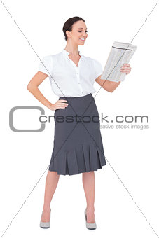 Cheerful stylish businesswoman holding newspaper
