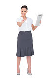 Stylish businesswoman pointing while holding newspaper