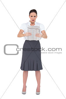 Stunned stylish businesswoman reading newspaper