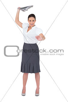 Angry stylish businesswoman throwing newspaper away