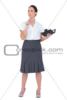 Pensive businesswoman holding datebook