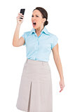 Angry classy businesswoman shouting at her smartphone