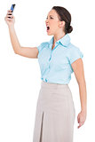 Angry classy businesswoman yelling at her smartphone