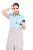 Worried classy businesswoman holding calculator