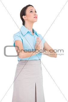 Worried young businesswoman praying