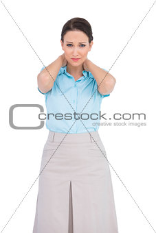 Pretty young businesswoman suffering from painful neck