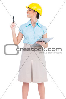 Cheerful attractive architect holding pen and clipboard