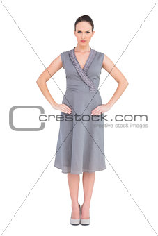 Frowning elegant brunette in classy dress posing