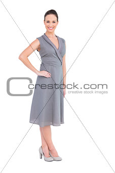 Happy elegant woman in classy dress posing hand on waist