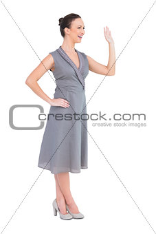 Happy elegant woman in classy dress waving