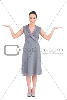 Cheerful elegant woman in classy dress posing hands up