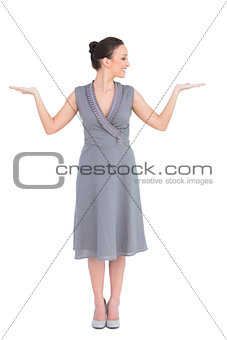 Smiling elegant woman in classy dress posing hands up