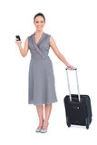 Cheerful gorgeous woman with her suitcase texting