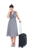 Gorgeous woman with suitcase having headache