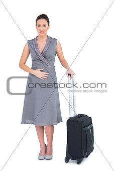 Gorgeous woman with suitcase having stomach ache