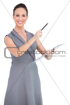 Cheerful seductive model pointing with pen