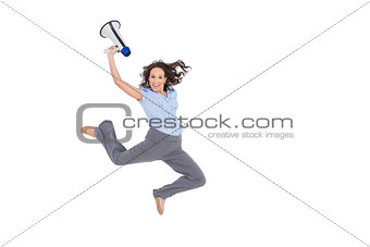 Cheerful classy businesswoman jumping while holding megaphone