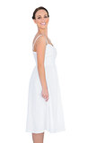 Smiling beautiful young model in white dress posing