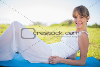 Smiling young woman relaxing on her mat