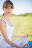 Serious young woman meditating in lotus position