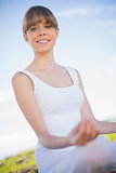 Smiling young woman relaxing in yoga position