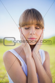 Pensive young woman posing closing eyes