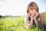 Smiling young woman on the grass looking at flowers