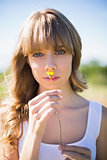 Pretty young woman smelling yellow flower